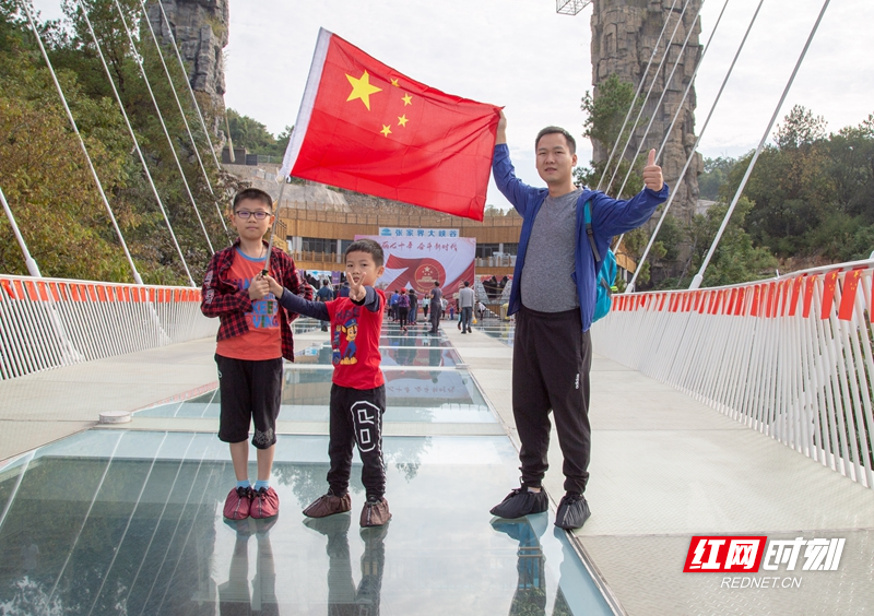 10月1日，张家界处处飘扬着鲜艳的五星红旗，将市城区和景区渲染成一片红色的海洋，市民游客以各种方式表达对祖国的祝福。各景区工作人员和游客一同收看收听庆祝中华人民共和国成立70周年大会、阅兵式和群众游行直播。（图：张潘、李森林、鄢渊、符伟、高双志、顾万双、碧霄、宋戈、张青青、吴勇兵、许志华）