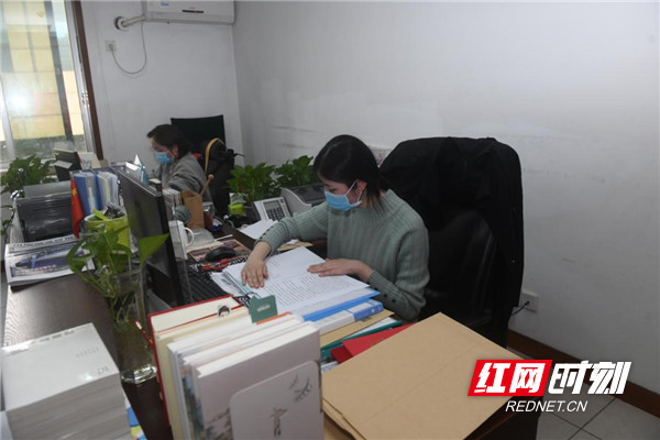 编辑助理在认真整理出版合同，加快书号申报工作。