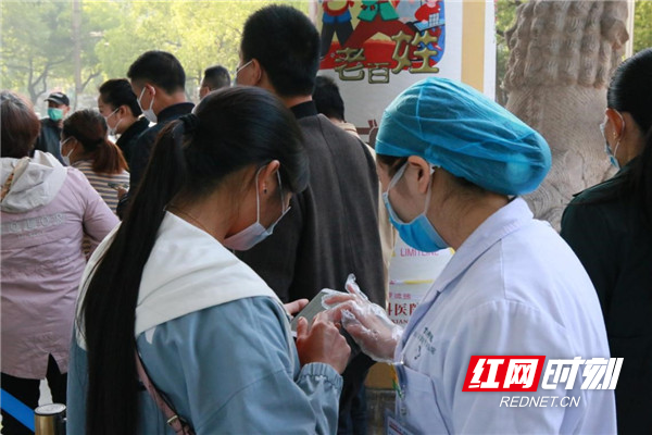 4月13日起，中信湘雅对全国所有地市全面开放各项医疗工作。现场人头攒动，图为医务人员引导病友进行居民健康卡查询。