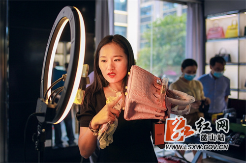 9月29日，蓝山县皮具箱包科技产业园电商直播间，主播在推介最新款的箱包产品。
近年来，蓝山县充分利用省级箱包皮具特色产业小镇的产品源头优势，积极探索直播电商销售新模式，通过建立电商培训基地、开设主播培训班等举措，大力扶持电商直播产业发展，为箱包产业发展注入新活力、提供新动能，产品热销欧美、韩国等国家和地区。
