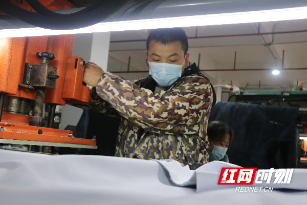 4月30日，道县高新技术开发区凯新鞋业有限公司生产车间，工人在裁剪鞋面材料。