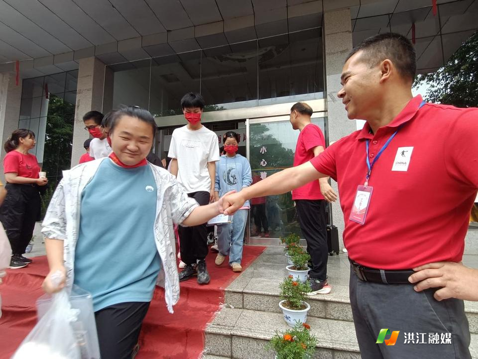 老师与学生亲切碰拳，为其加油鼓劲。