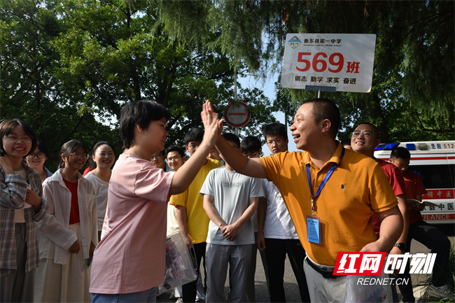 6月7日，湖南省衡阳市衡东县第一中学高考考点，送考班主任分发准考证，并与考生击掌握手，加油鼓劲。（肖亚辉/摄）