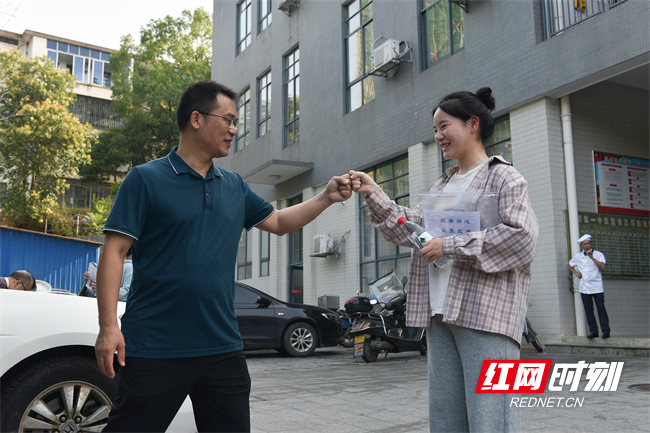 6月7日，湖南省衡阳市衡东县第一中学高考考点，送考班主任分发准考证，并与考生击掌握手，加油鼓劲。（肖亚辉/摄）