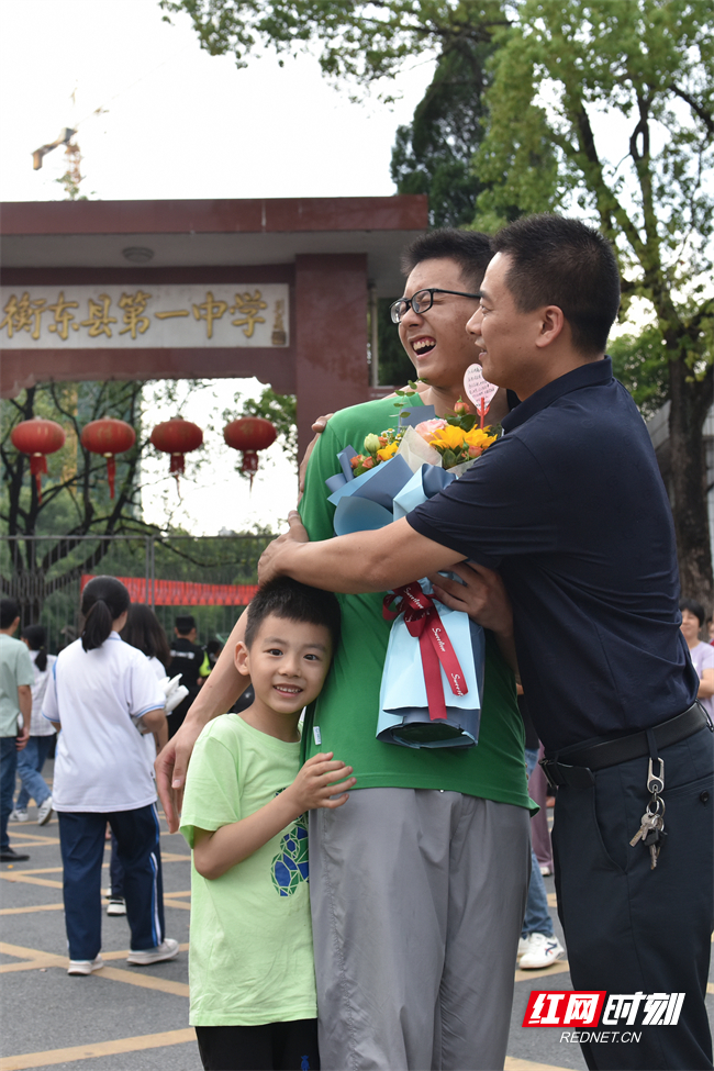 6月9日下午，2023年湖南高考圆满结束。在湖南省衡东县第一中学，场外家长或手捧鲜花，或手牵二娃，或全家出动，在考点外迎接高考娃大胜归来。（肖亚辉/摄）