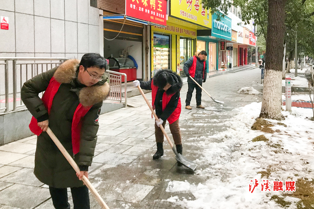 图：泸溪县商务局志愿者开展积雪清扫活动