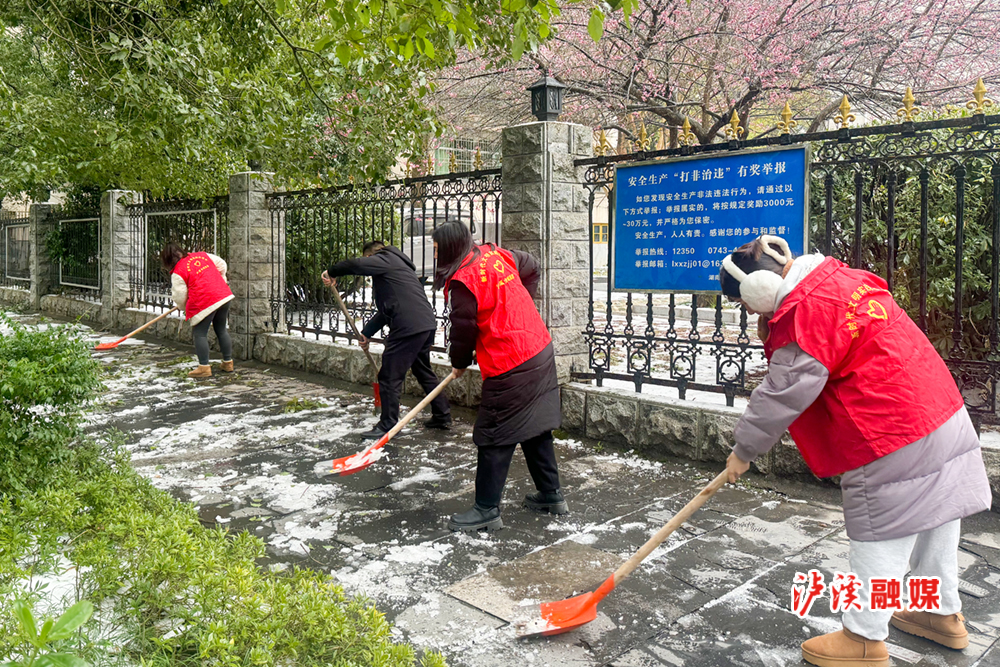 图：泸溪县全域旅游公司志愿者开展积雪清扫活动