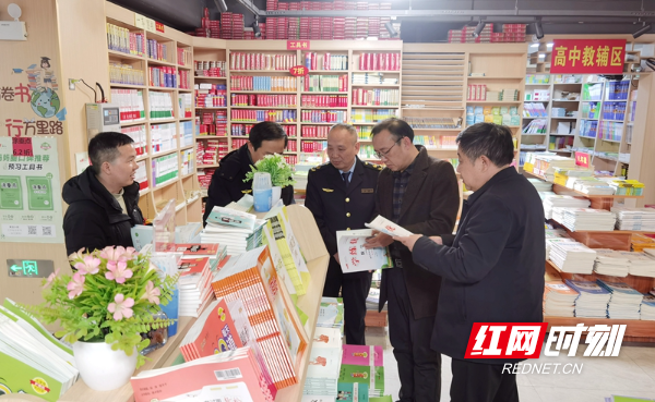 永州市一书店，文化执法人员在查看出版物信息。（周志刚  摄）.jpg