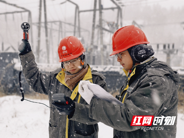 图二：1月9日，国网邵阳供电公司小沙江供电所汪邹平和钱仕林在110千伏小沙江变电站外测量风速。（刘靖）_副本.jpg