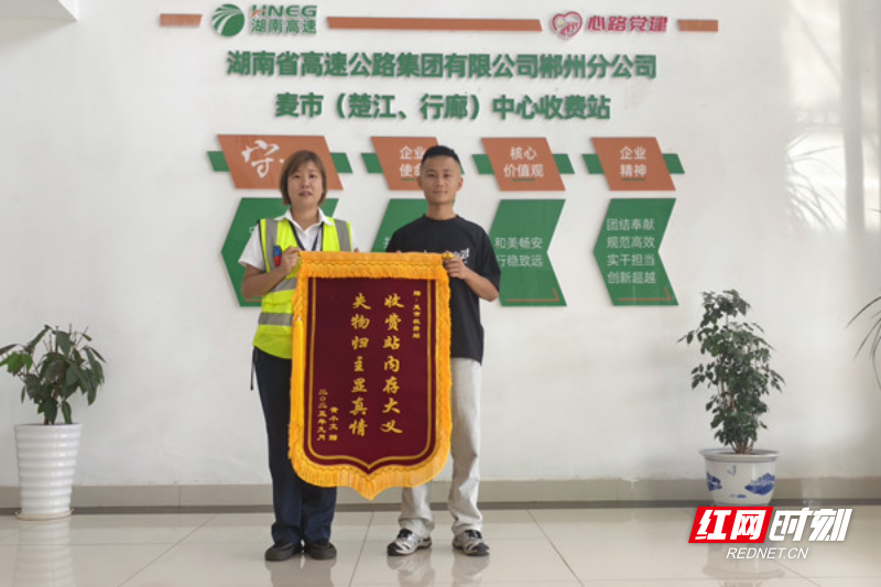麦市中心站收费班长朱玲霞与送锦旗的黄先生合影.jpg