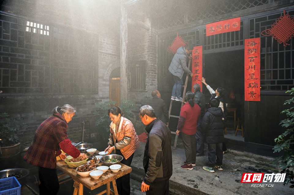 《小院年味》2025年1月19日,湖南省汝城县永丰村。新年将至,家中长辈忙着准备美食,年轻人登高贴起春联。小院里弥漫着烟火气,那是团圆的味道,也是年的味道。.jpg