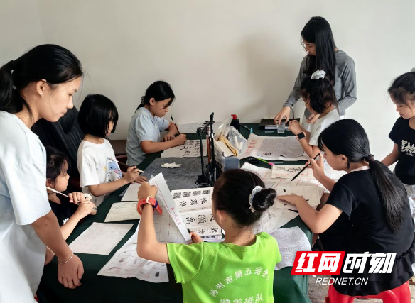 志愿者组织孩子们临摹书法.jpg